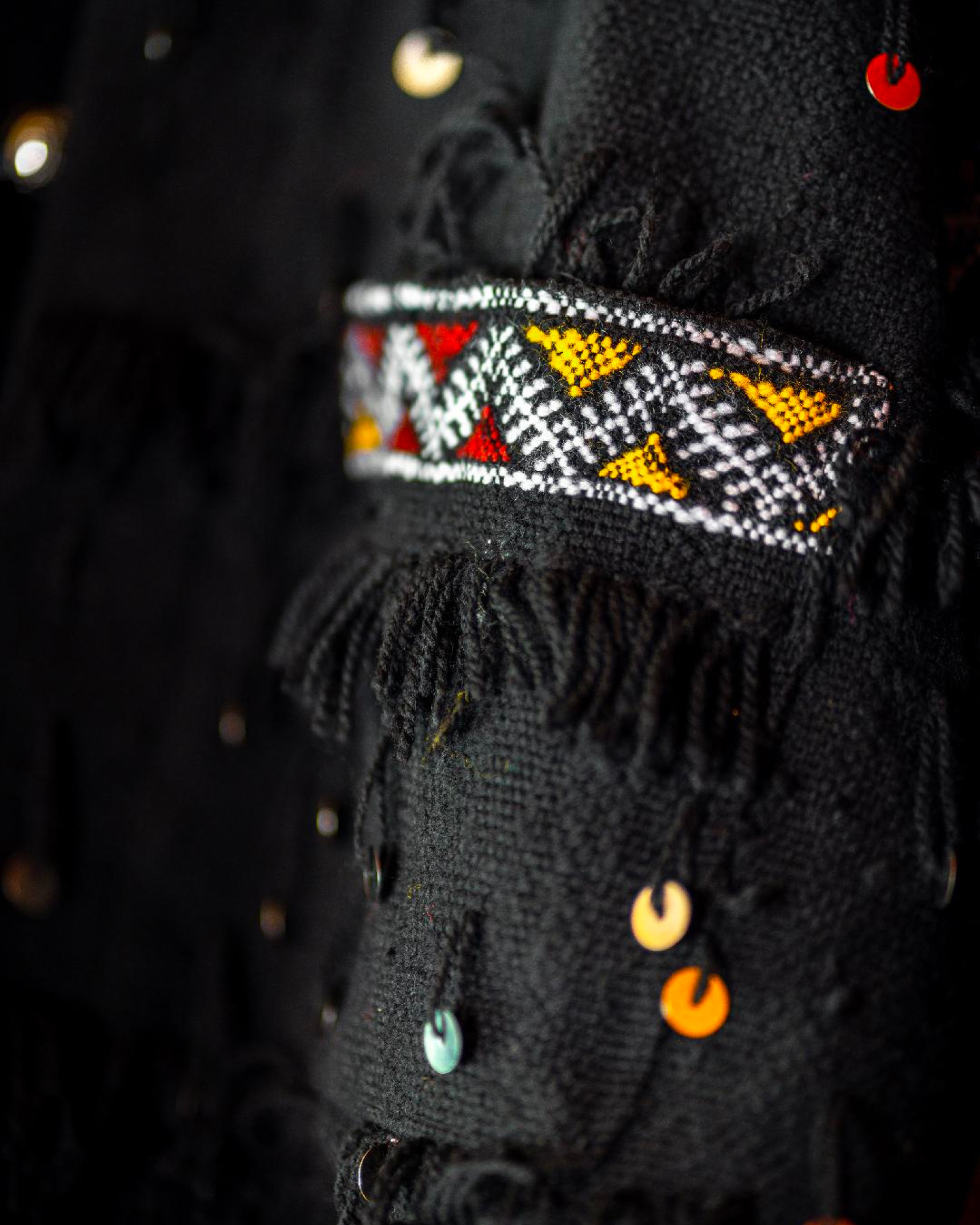 Close-up of the Amazigh geometric trim and sequins on the black jacket